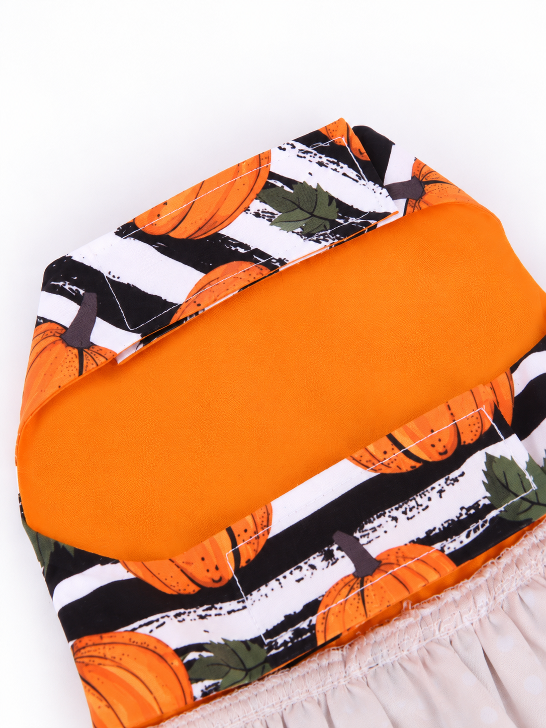 Inside view of orange lined Pumpkin Bow Halloween pet dress with back fastening tabs