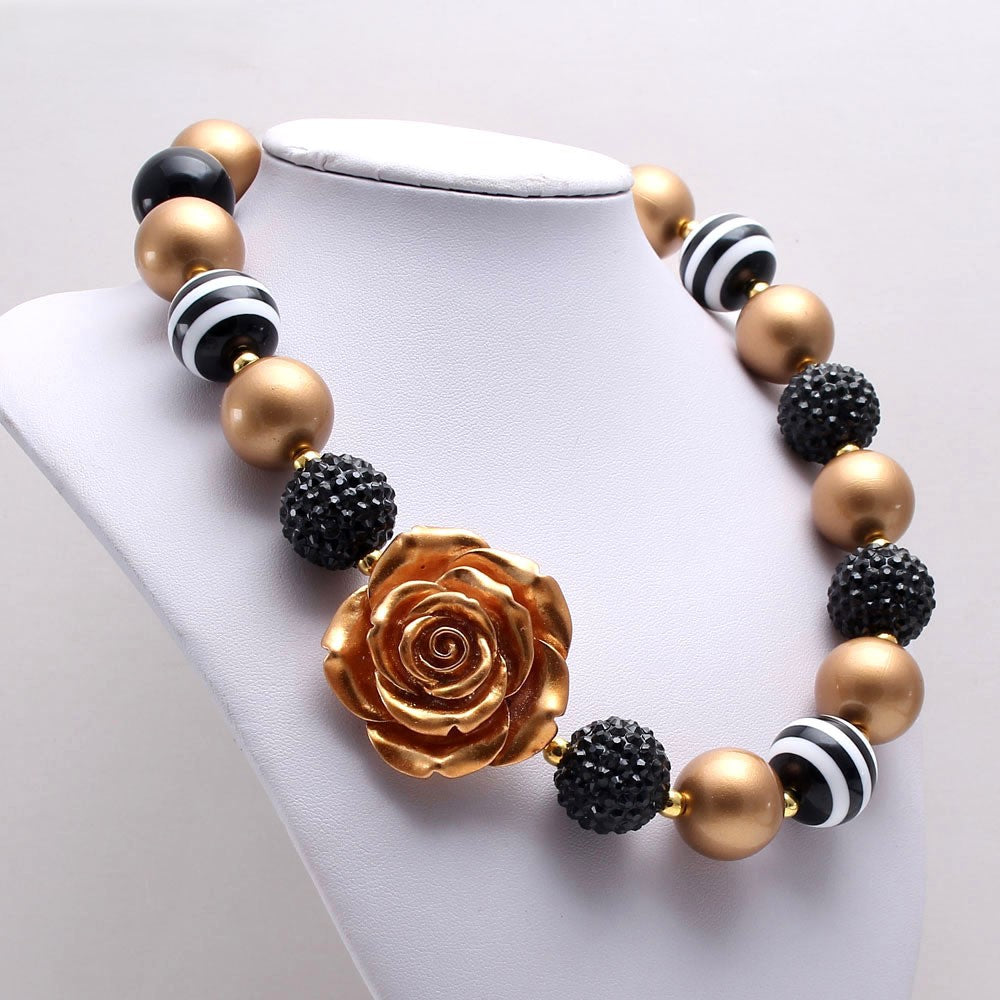 Angled display of black gold and striped bead pet necklace with rose accent
