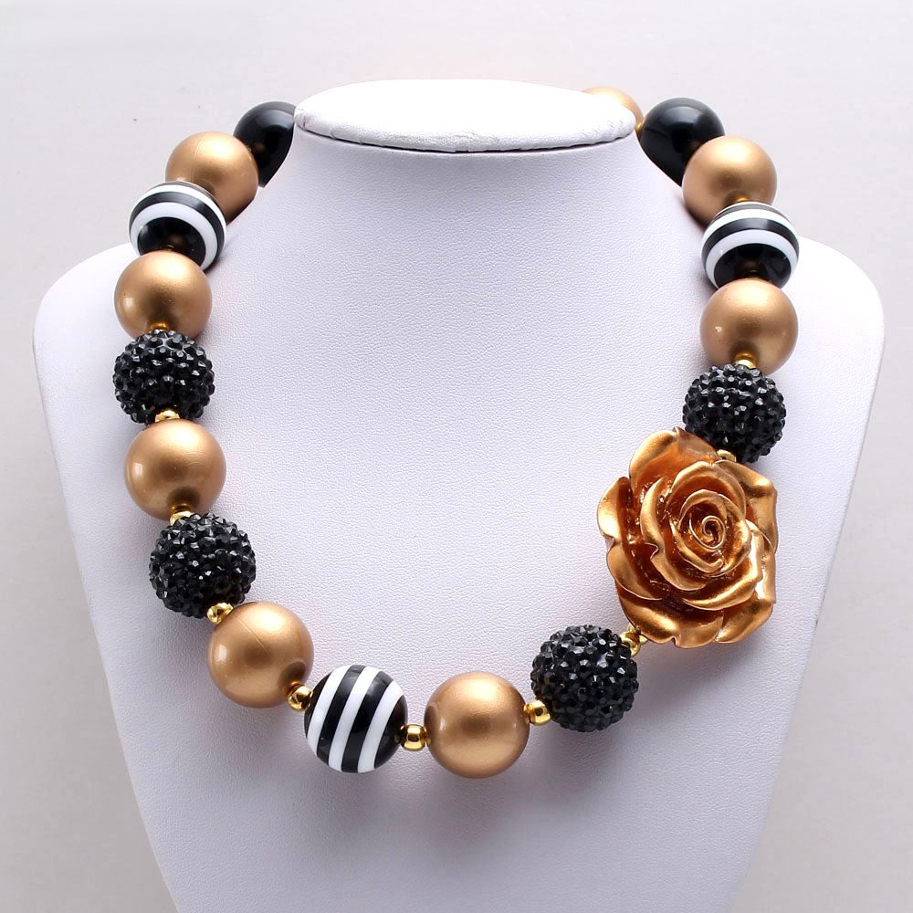 Black and gold beaded pet necklace with rose centerpiece on white display bust