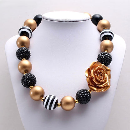 Black and gold beaded pet necklace with rose centerpiece on white display bust