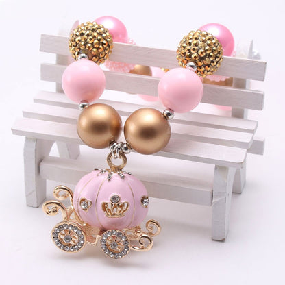 Close view of pink pumpkin carriage pendant and mixed gold beads