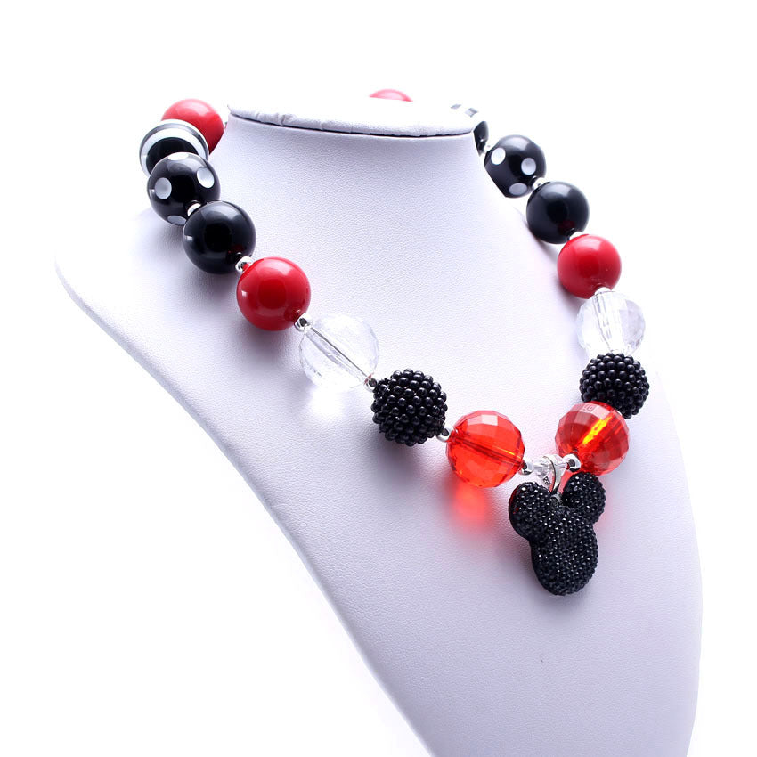 Red and black beaded dog necklace displayed on a white jewelry bust