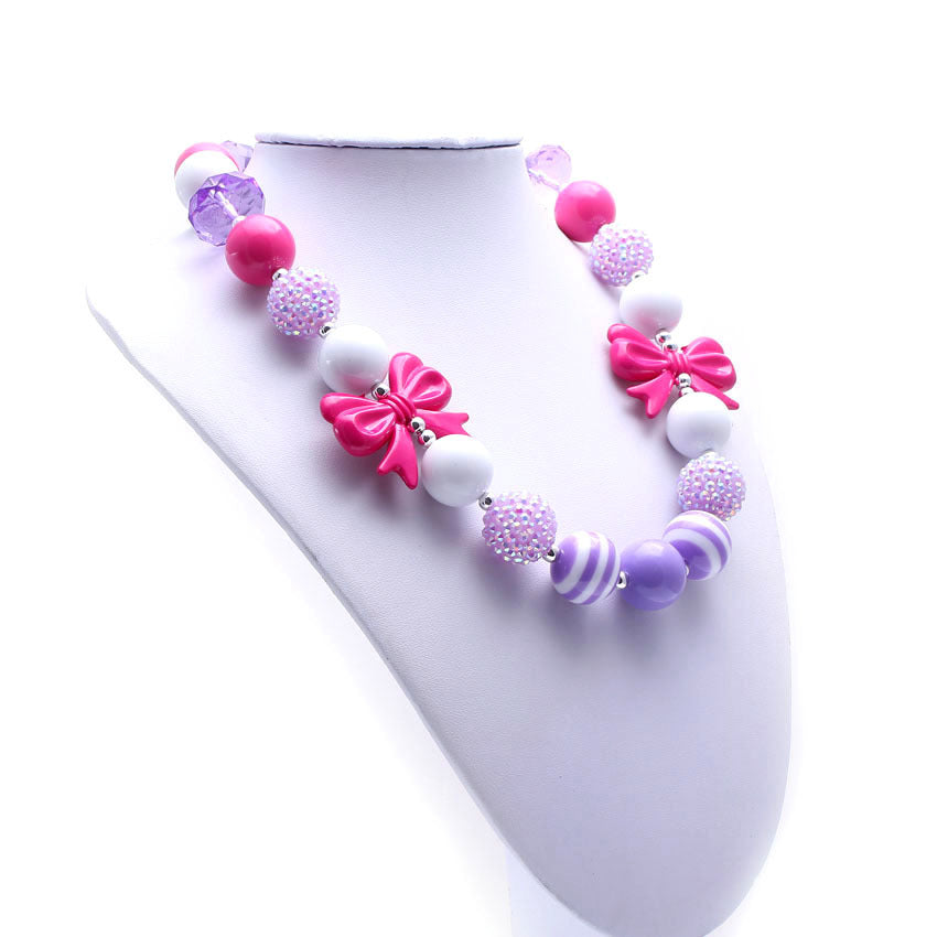 Angled view of pink bow beaded pet necklace on white jewelry bust