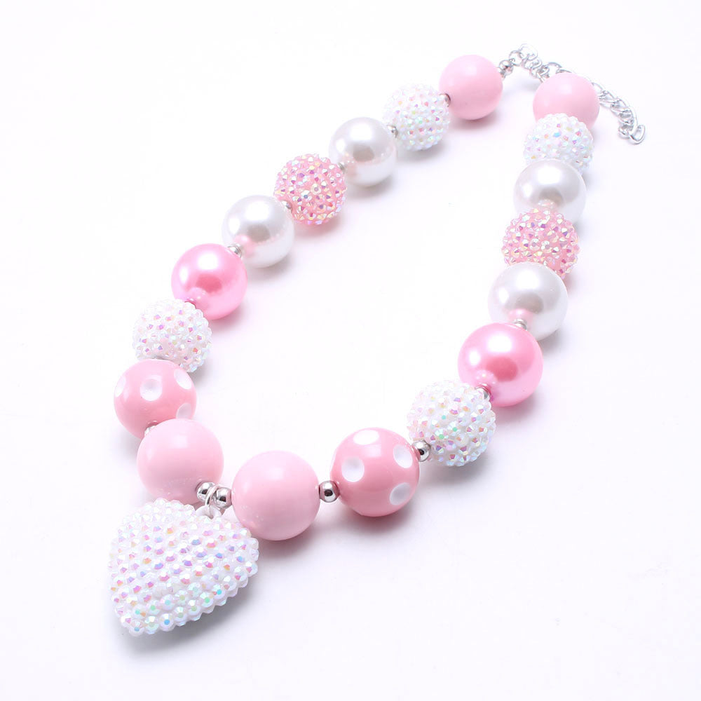 Flat lay of Pink White chunky beaded dog necklace with heart-shaped accent