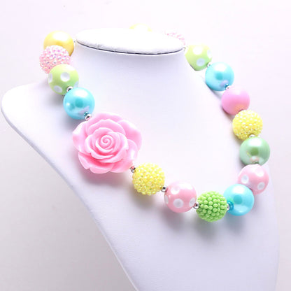 Angled view of pastel acrylic bead dog necklace with large pink rose