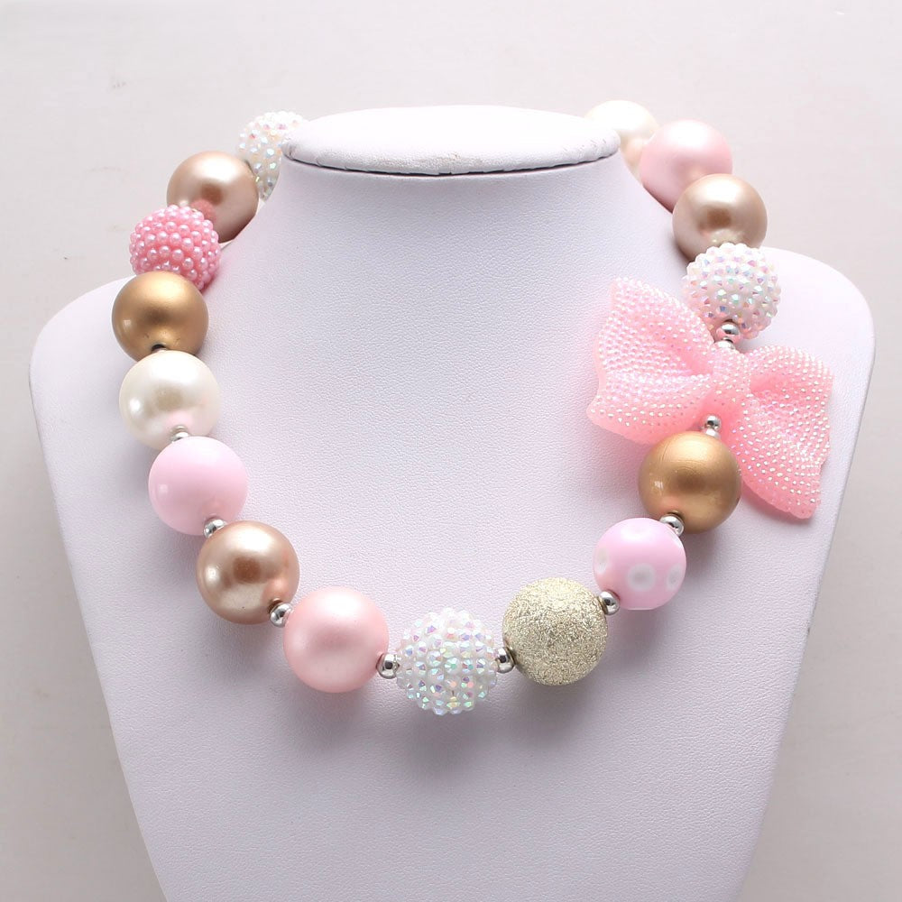 Pink Gold acrylic bead dog necklace with bow displayed on white bust