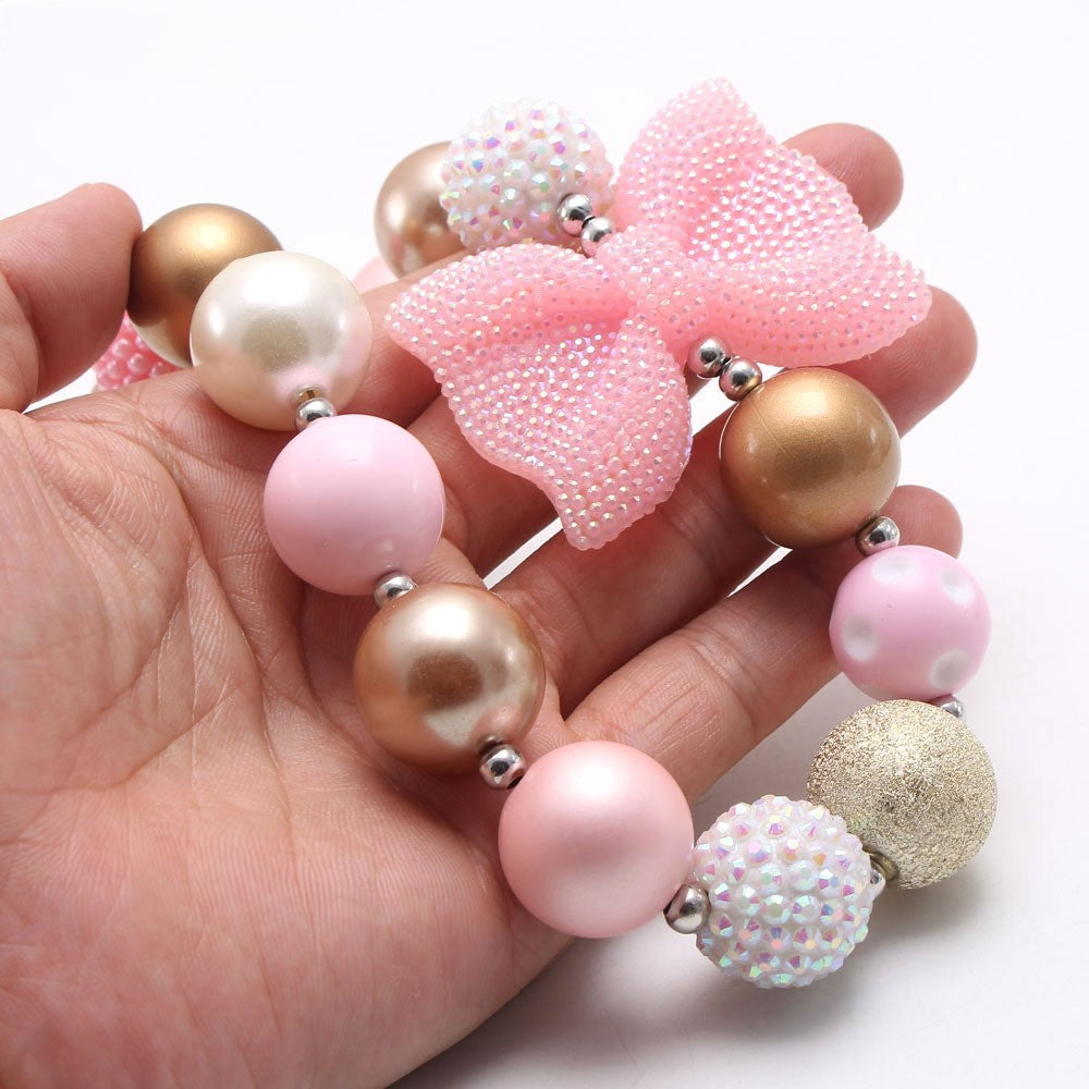 Close view of Pink Gold chunky beaded pet necklace with textured pink bow