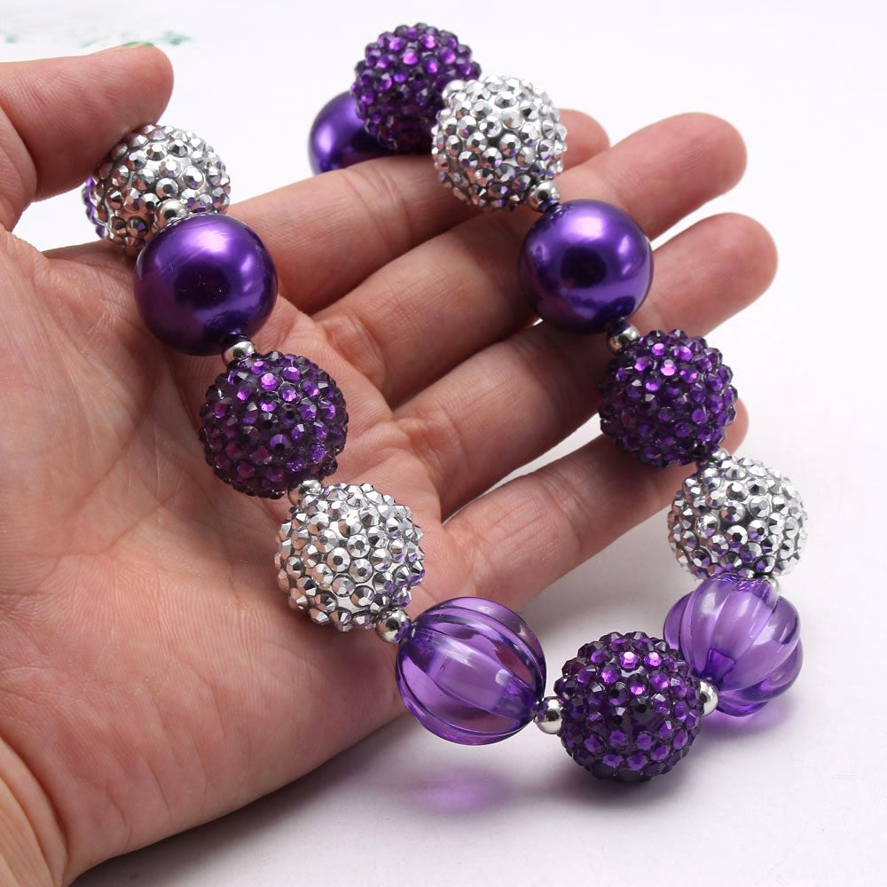 Close-up of purple silver acrylic dog necklace with pearl-look and textured beads