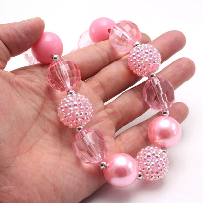 Close-up of pink sparkle acrylic beaded dog necklace with faceted and pearl-look beads