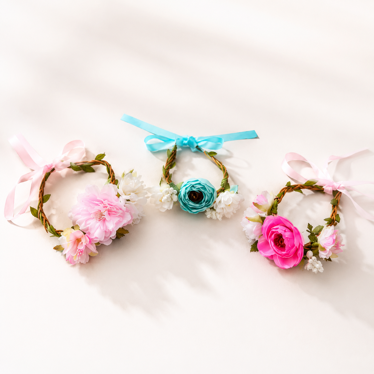 Three pet floral crown headpieces in pink blue and hot pink styles