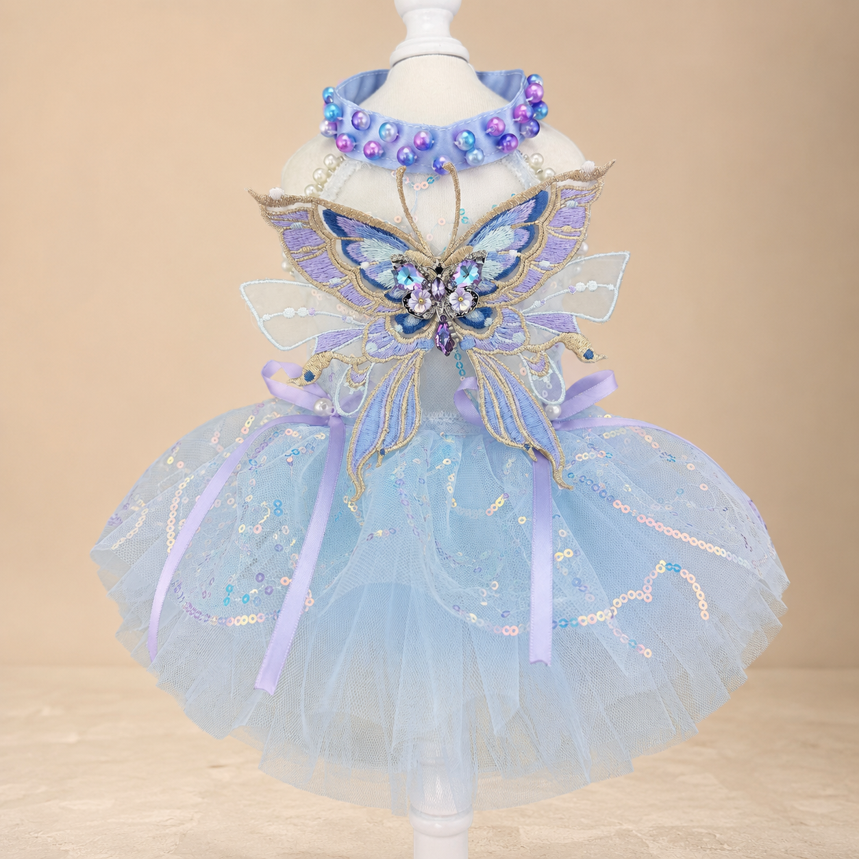 Close-up of blue butterfly pet dress with embroidered butterfly and sequined tulle