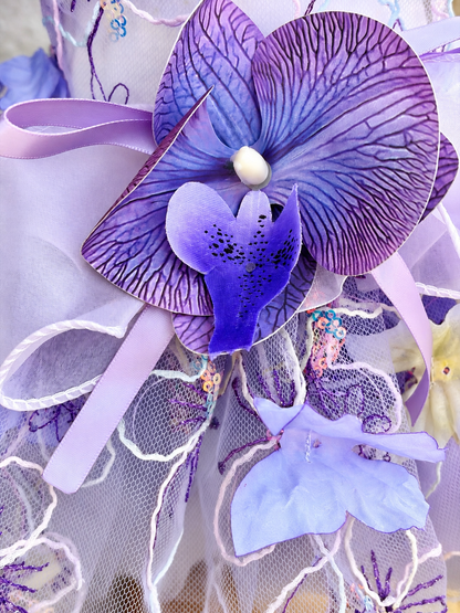 Close-up of purple orchid-style flower accent on Lavender pet dress