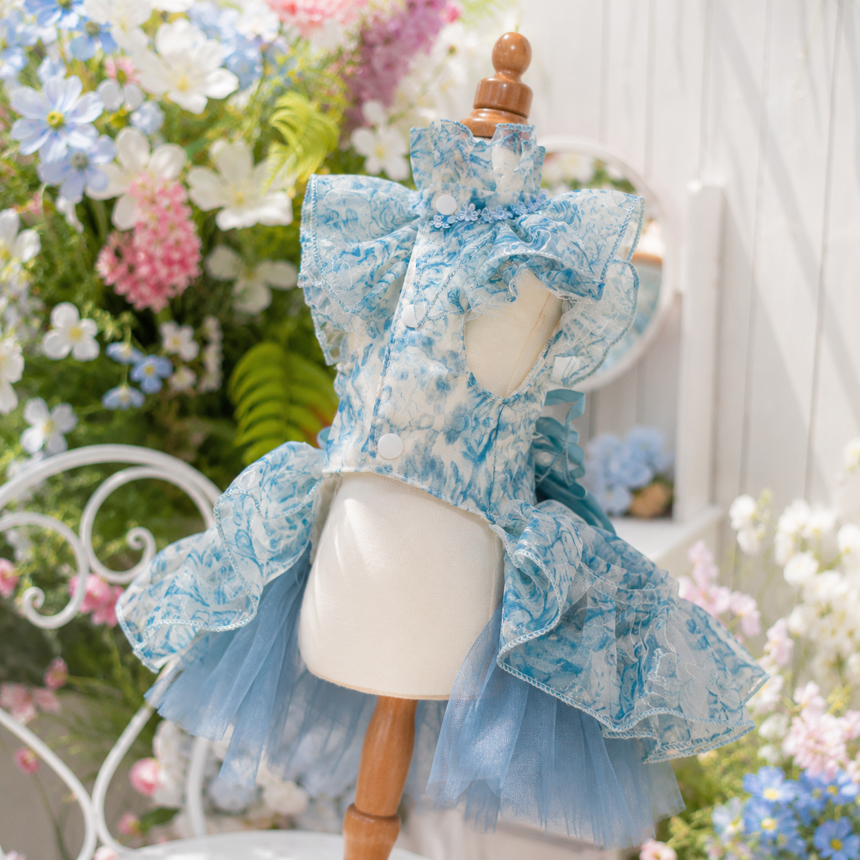 Back view of blue floral pet wedding dress featuring satin bow accents, layered ruffles, and elegant floral details