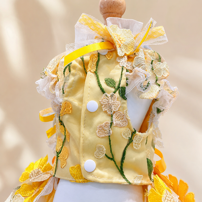 Back detail of yellow floral pet gown with buttons, ribbons, and sheer ruffles