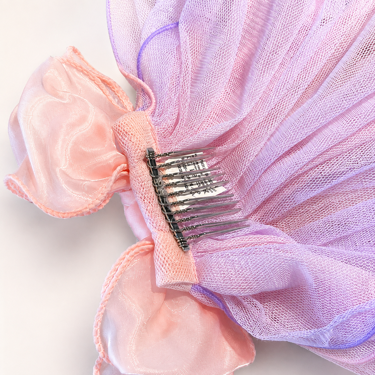 Back detail of pink tulle flower pet veil hair clip showing comb clip and mesh layers