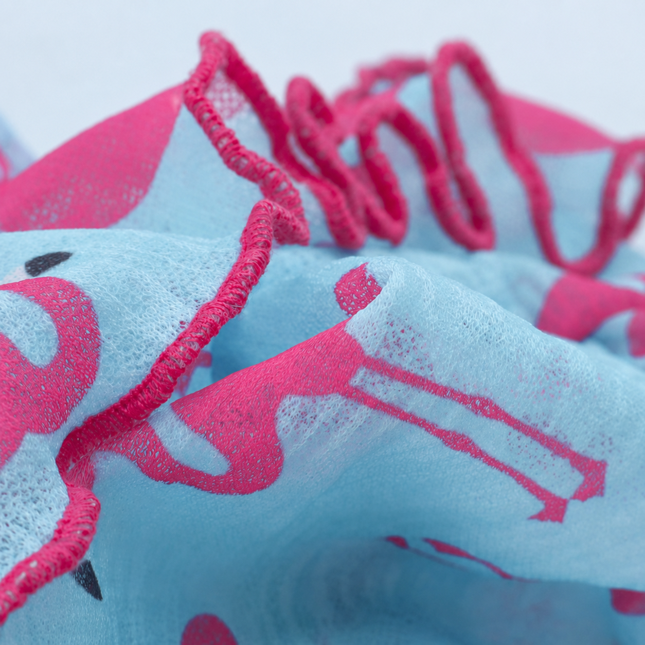 Close-up of the blue fabric and hot pink ruffle trim on the flamingo dog dress