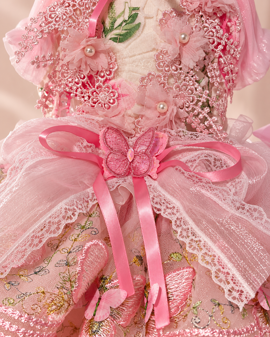 Close-up of pink pet dress butterfly bow floral lace and pearl-style details