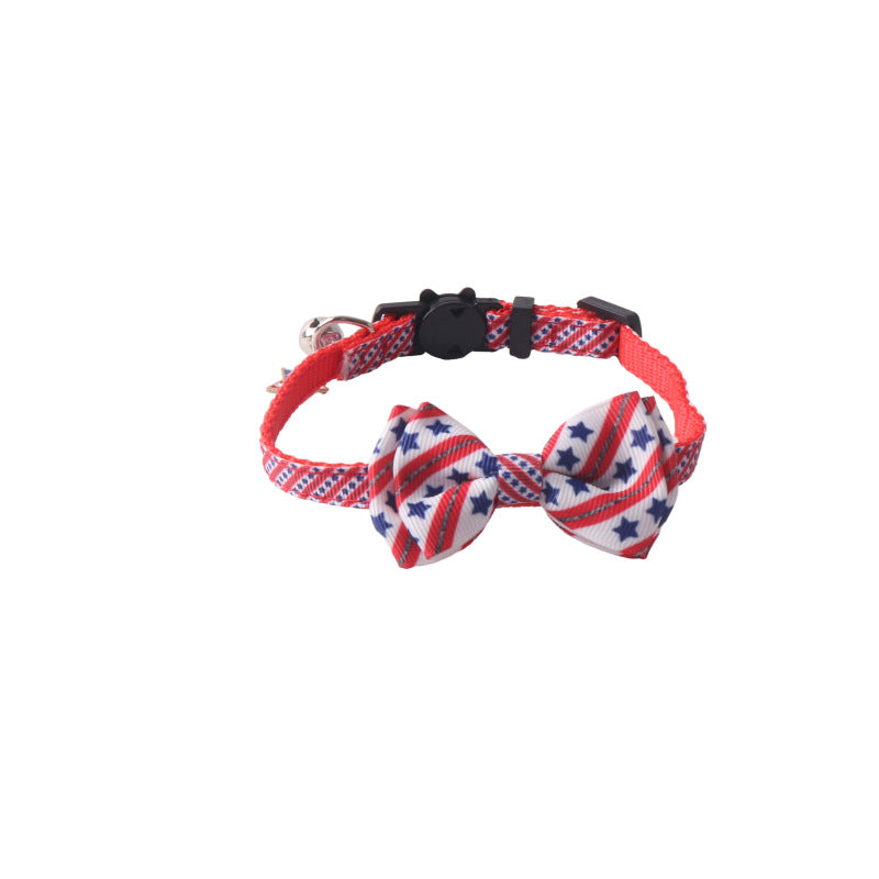 Red, white, and blue star bow tie cat collar with bell and black buckle on white background