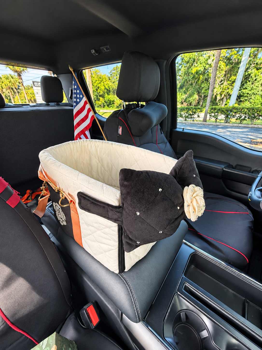Pet car seat carrier displayed on a wide vehicle center seat