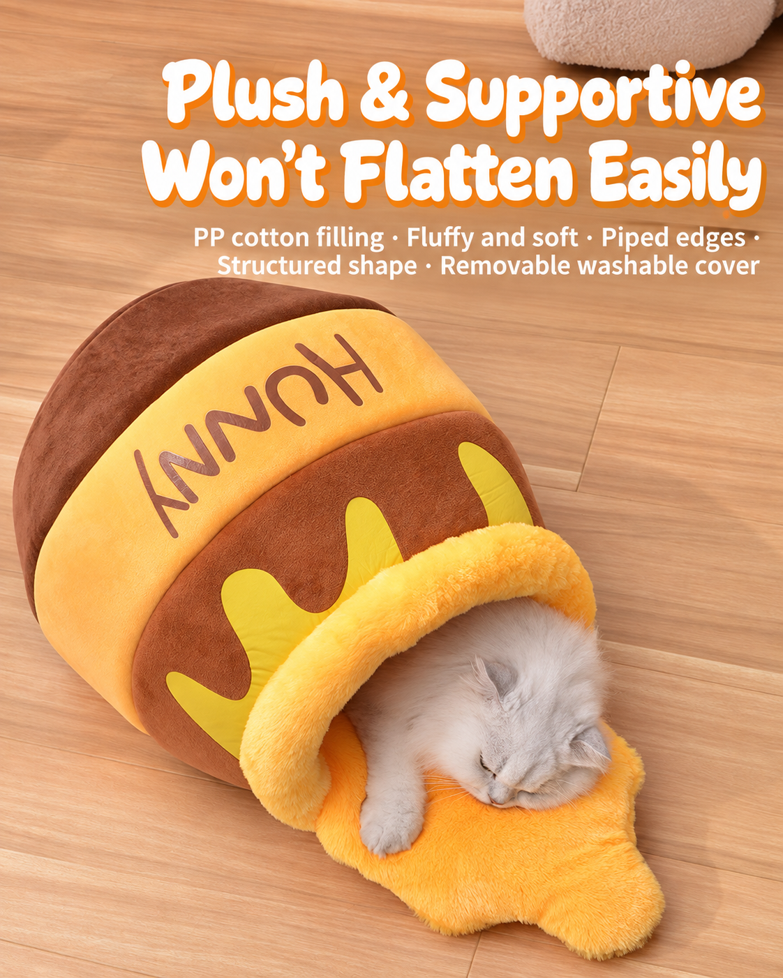 White cat resting inside the honey pot sleeping bag pet bed on a wood floor
