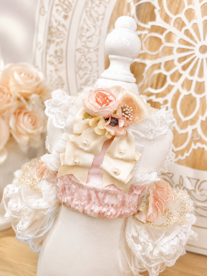 Back view of couture dog dress featuring elegant bow, floral corsage and layered lace ruffles