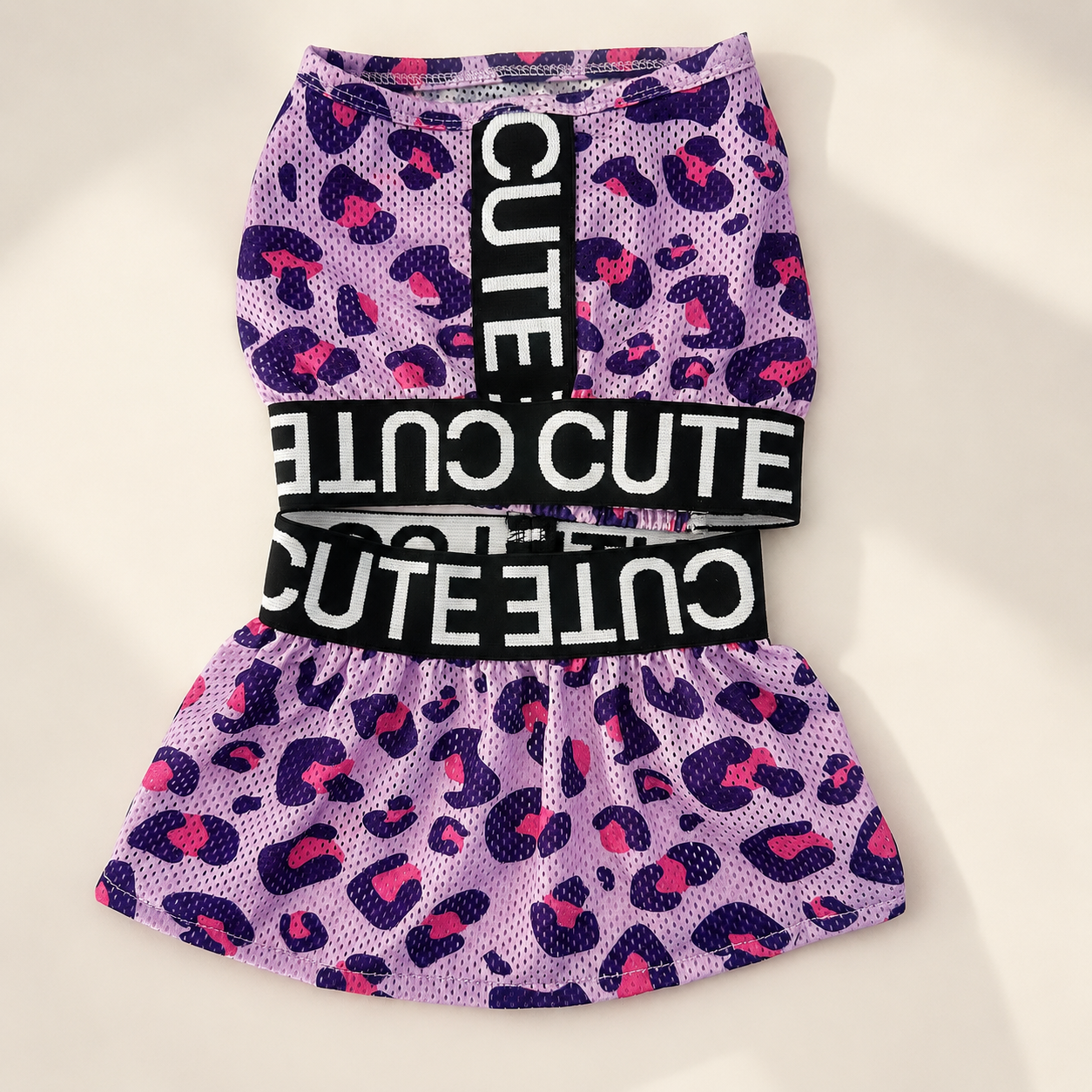 Front flat lay of the pink leopard 2-piece dog dress set with black letter bands