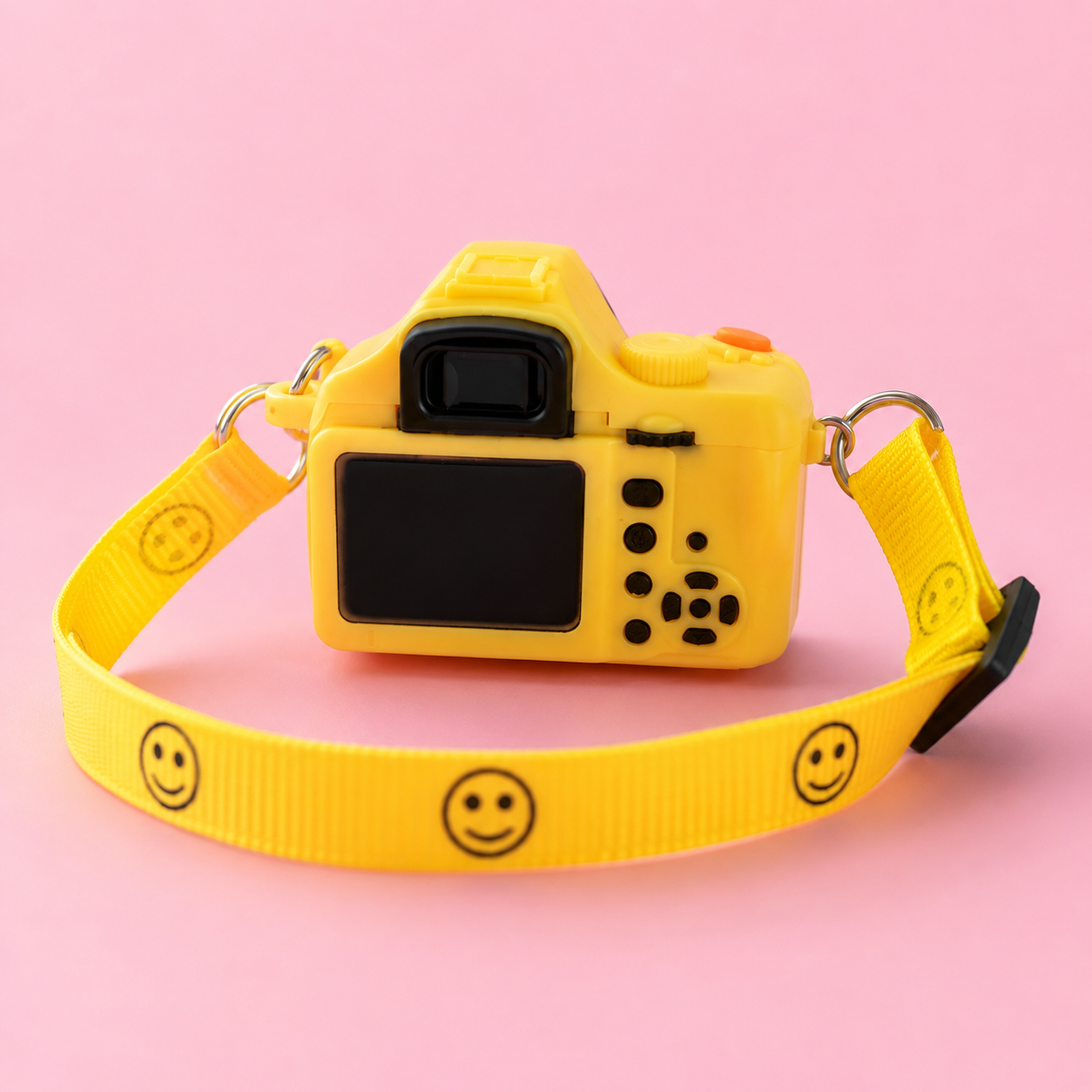 Yellow interactive camera pet necklace close-up showing decorative lens, shutter button and adjustable smile-print strap