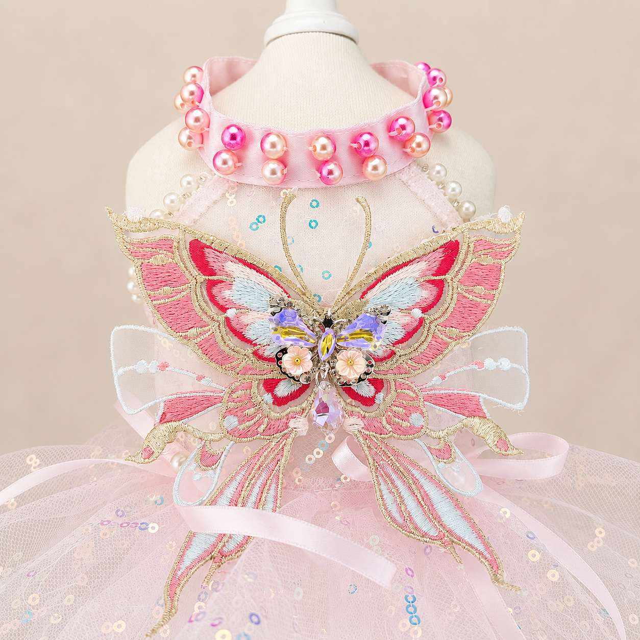 Close-up of pink butterfly pet dress with embroidered butterfly and bead details