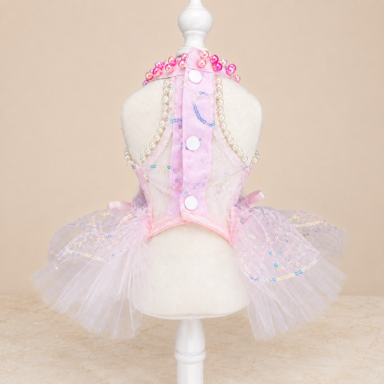 Back view of pink tulle pet dress with white buttons and pearl-like trim