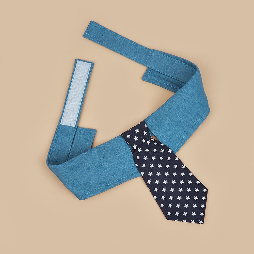 Close-up of adjustable blue pet tie collar featuring hook-and-loop closure and navy necktie with white star pattern