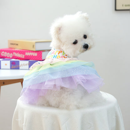 Small white dog wearing Happy Birthday rainbow tulle pet dress from back view