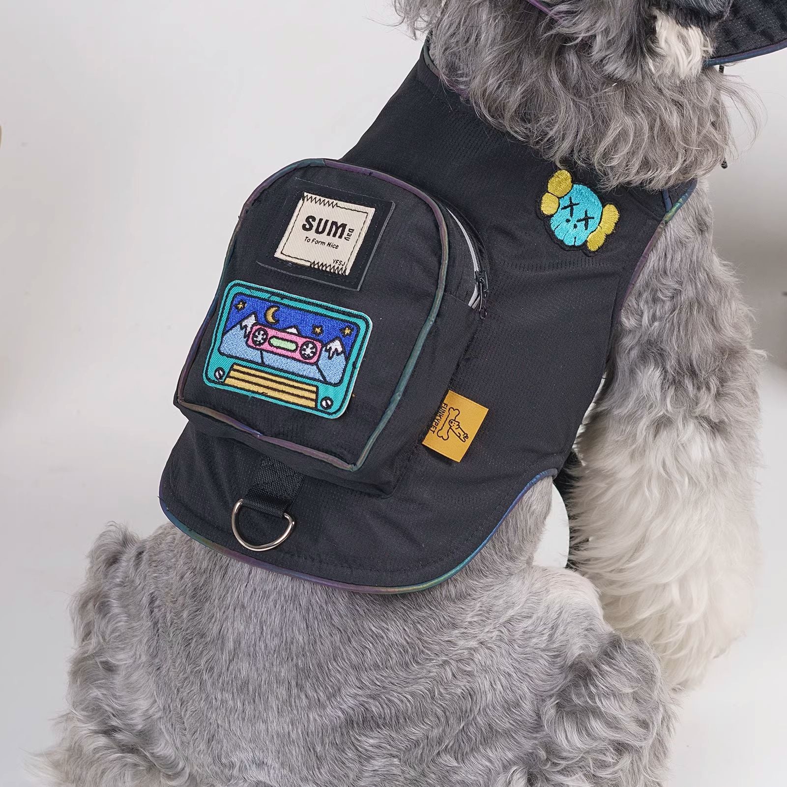Close-up of black backpack pouch and embroidered patch on dog harness vest