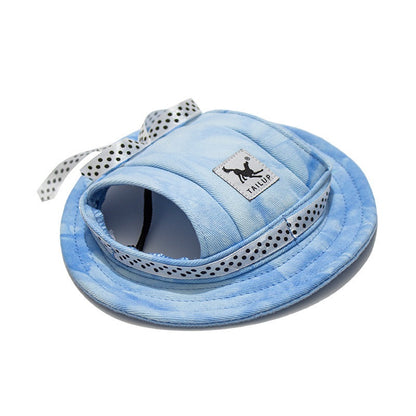 Blue pet sun hat with ear holes and polka dot bow on white background