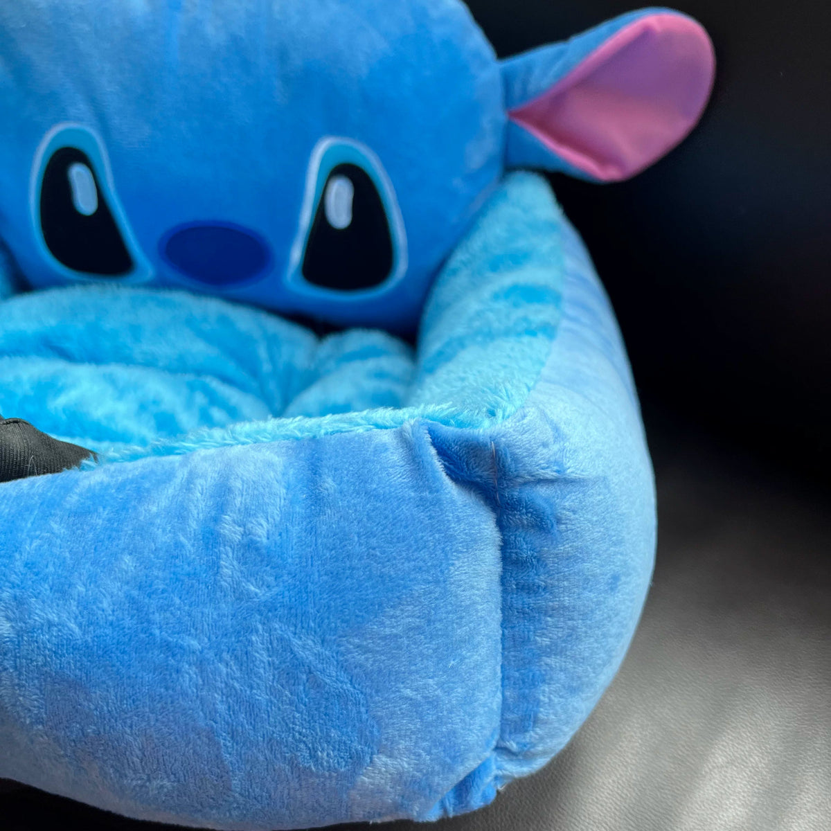 Front corner detail of the blue plush bolster and Stitch backrest