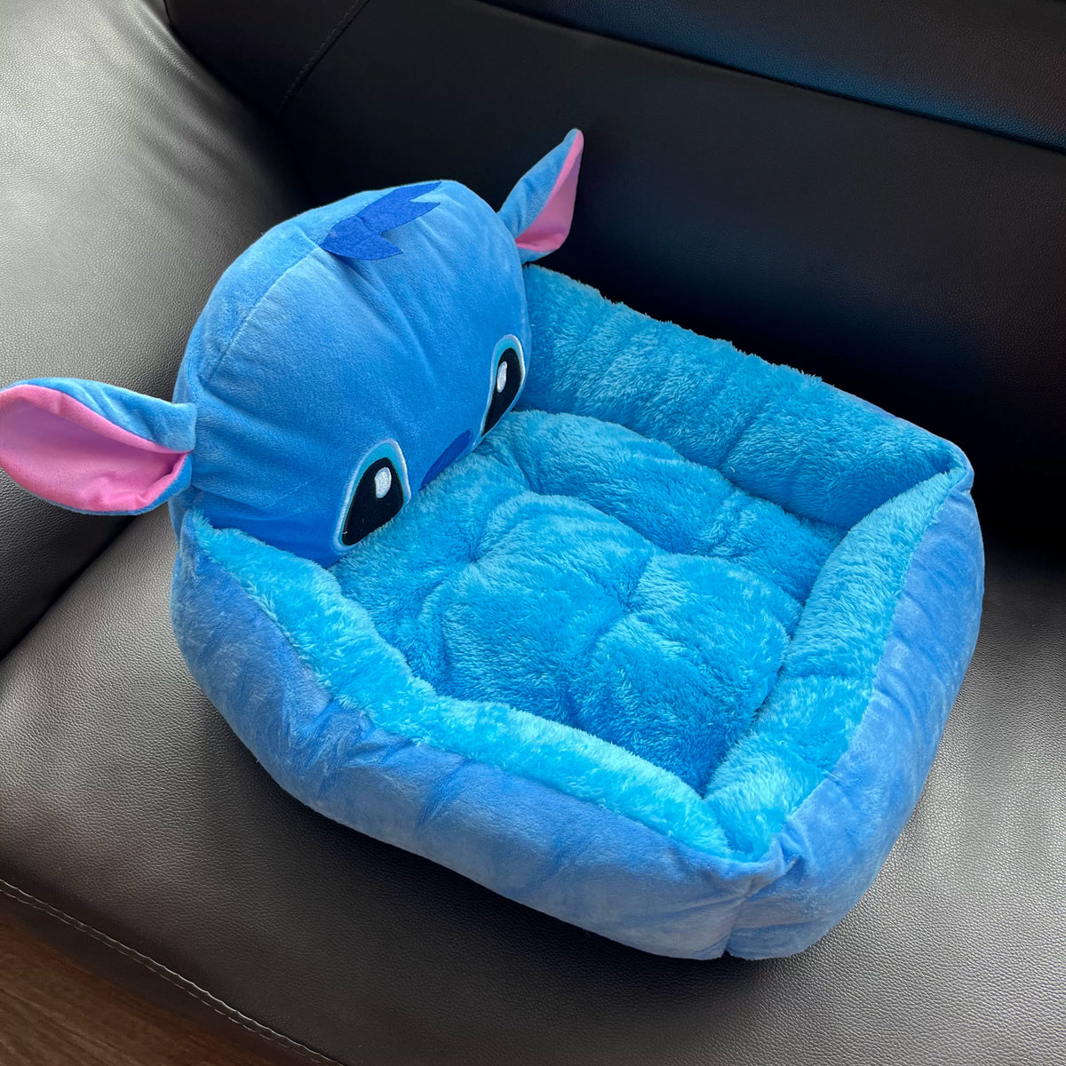 Angled view of the blue Stitch pet bed with low front entry