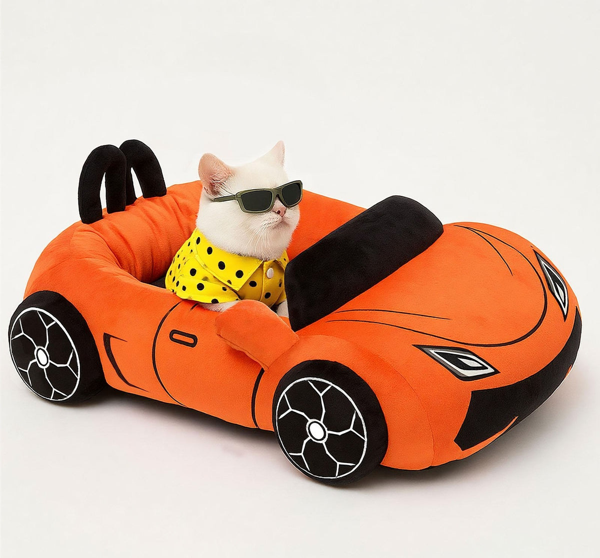 White cat sitting in an orange convertible sports car-shaped pet bed
