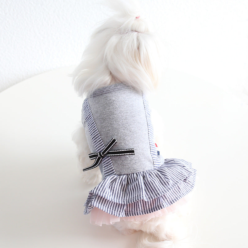 White dog modeling gray striped pet dress with bow and tiered skirt