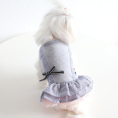 White dog modeling gray striped pet dress with bow and tiered skirt