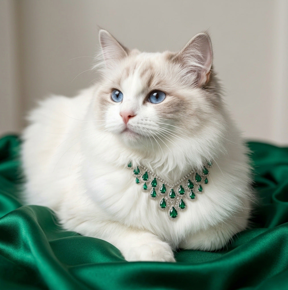 Green statement pet necklace on white cat with teardrop jewel-style accents and green satin background