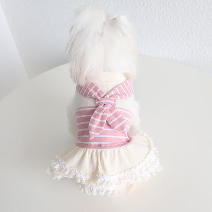 Small white dog modeling the pink sailor dress from the back