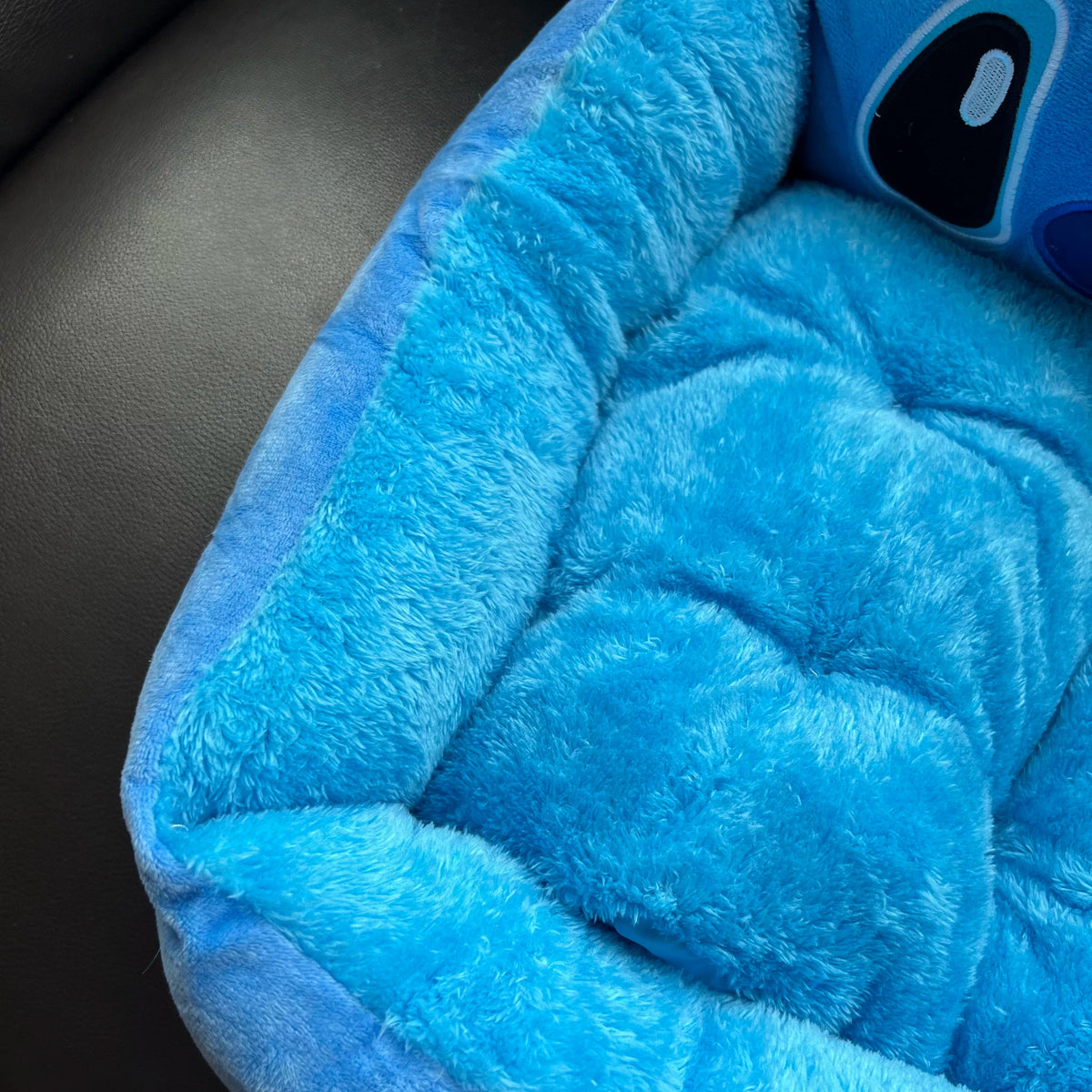Tufted fuzzy cushion and raised side of the Disney Stitch pet bed