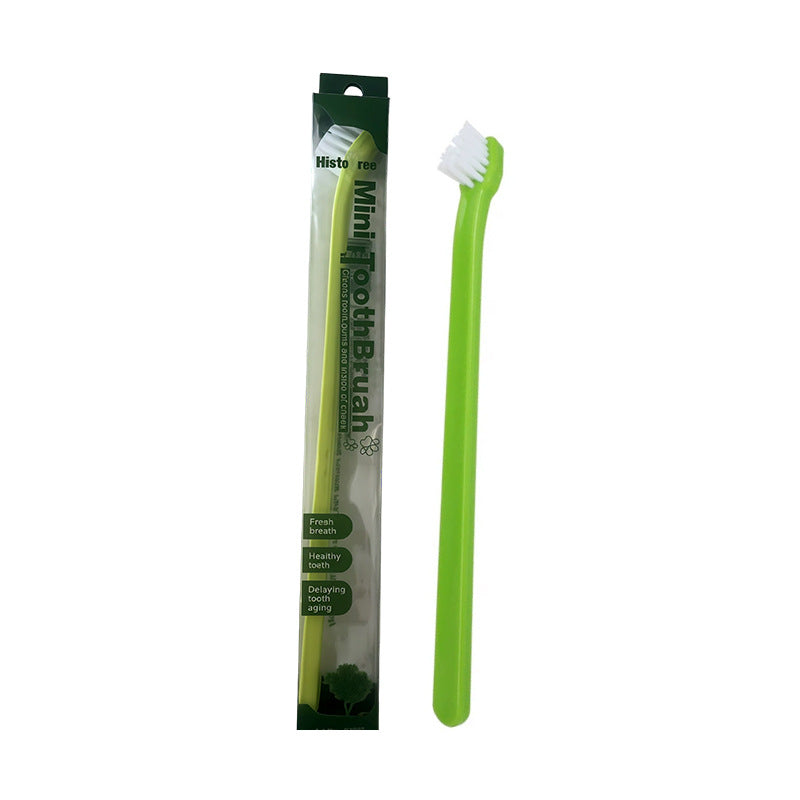 Green mini pet toothbrush beside green and white package