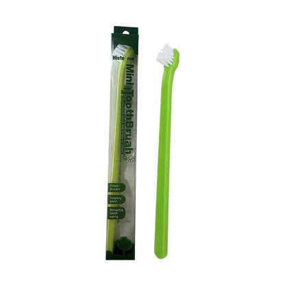 Green mini pet toothbrush beside green and white package