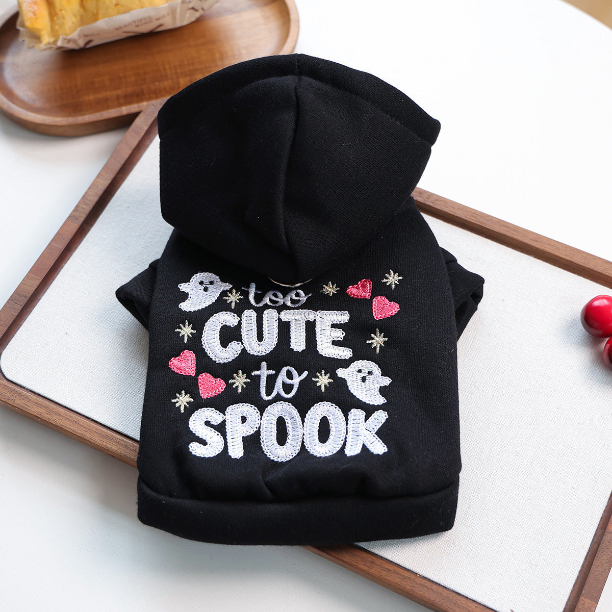 Black hooded pet sweatshirt laid flat with embroidered ghosts hearts and lettering