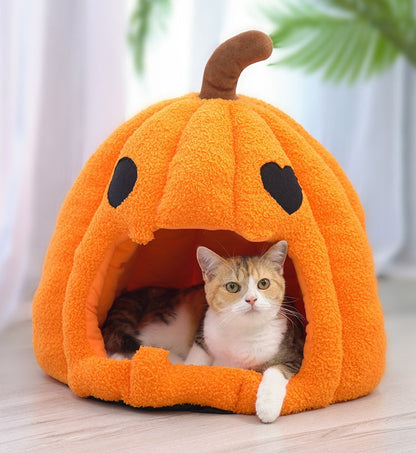 Cat resting inside an orange Halloween pumpkin pet cave bed