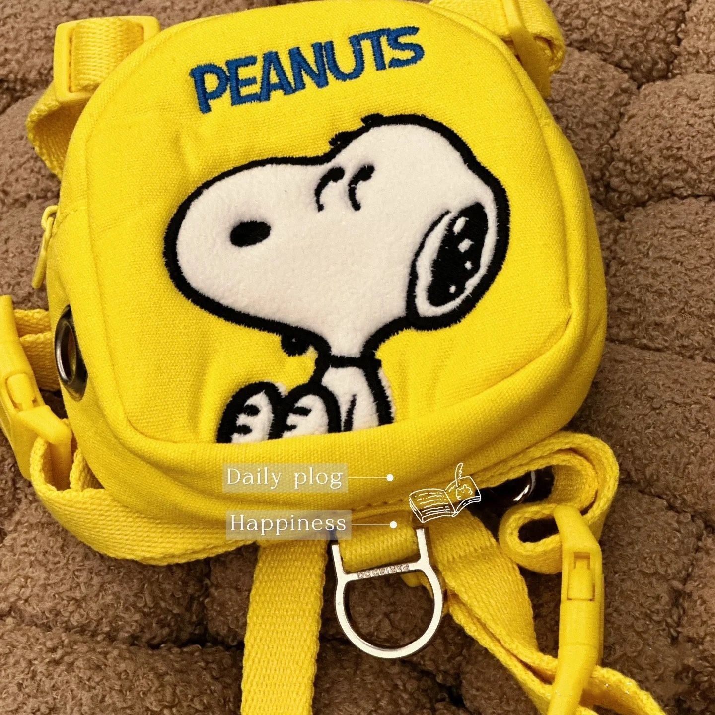 Detail view of yellow cartoon patch pouch with leash ring on dog harness