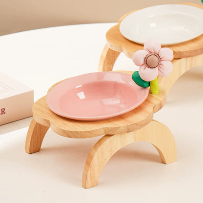 Yellow ceramic elevated dog bowl with wooden stand and flower decoration
