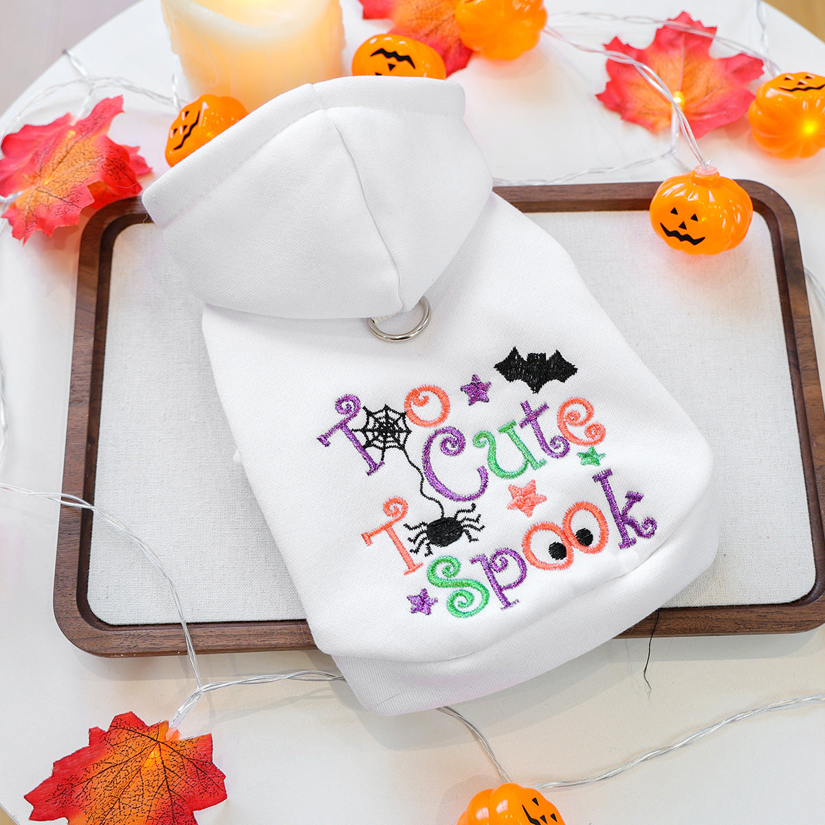 White Halloween pet hoodie laid flat with colorful Too Cute to Spook embroidery