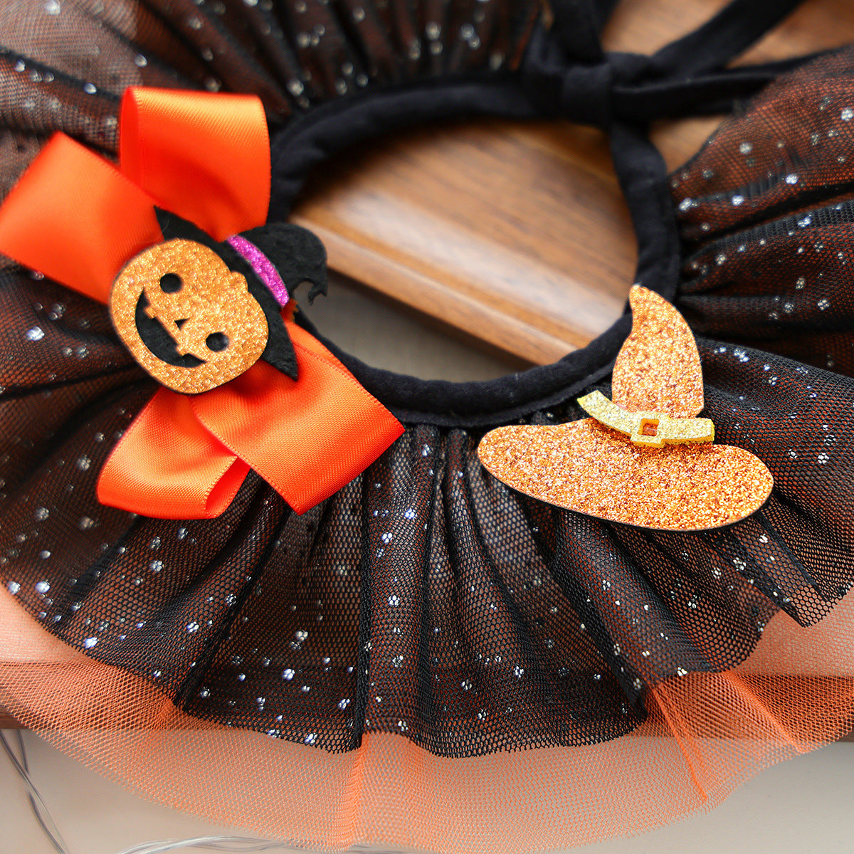 Close-up of glitter-look witch hat and pumpkin decorations on pet collar