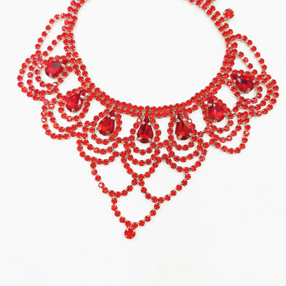 Red pet necklace close-up with teardrop jewel-style accents and layered scalloped front